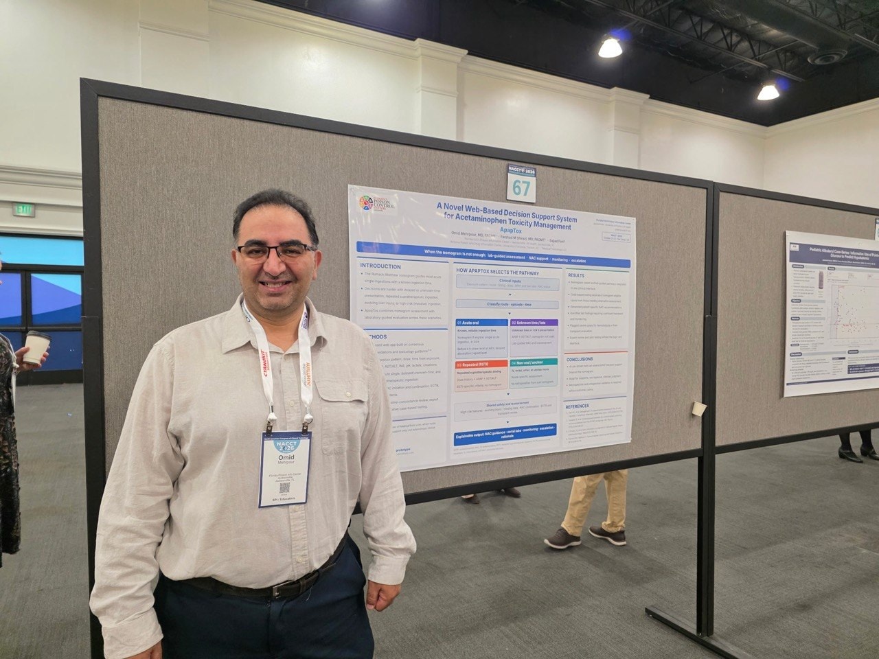 Dr. Omid Mehrpour standing beside the ApapTox poster, board number 67, in the NACCT 2026 poster hall.